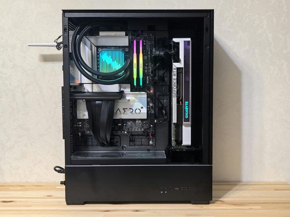 自作デスクトップPCの内部で、電源が正常に入り各種コンポーネントが点灯した状態。CPUクーラーのポンプやRAMモジュールがRGB発光し、ビデオカード上の「GEFORCE RTX」「GIGABYTE」ロゴも光っている。最終チェックでマザーボードが無事通電し正常動作していることを示すまとめのイメージ。